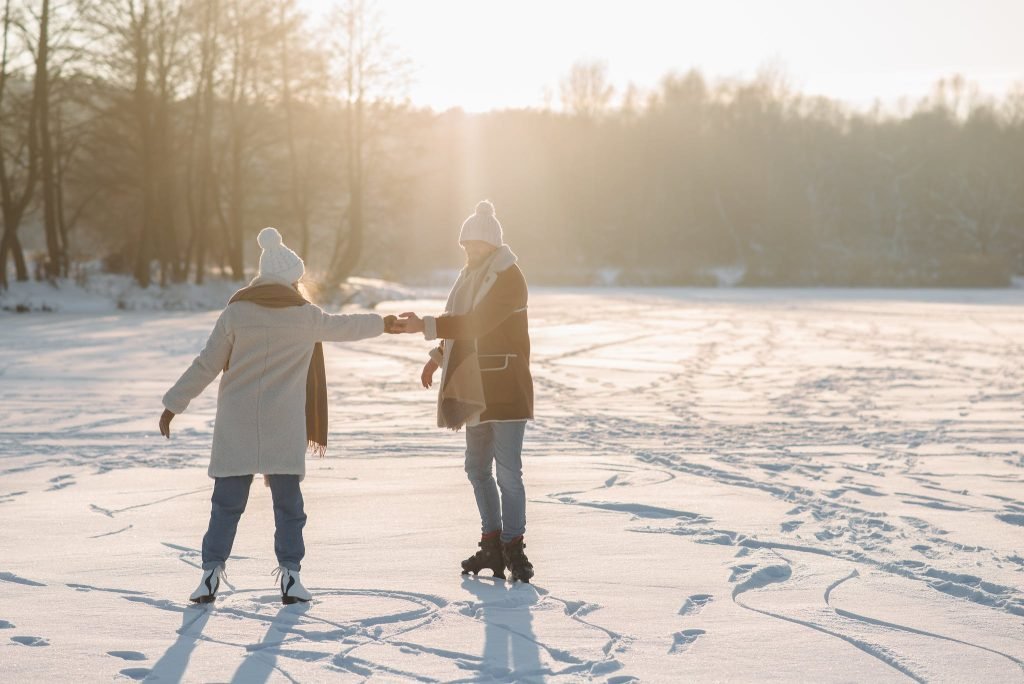 Couple Holding Hands While Doing Ice Skating - things to do in New England this winter.